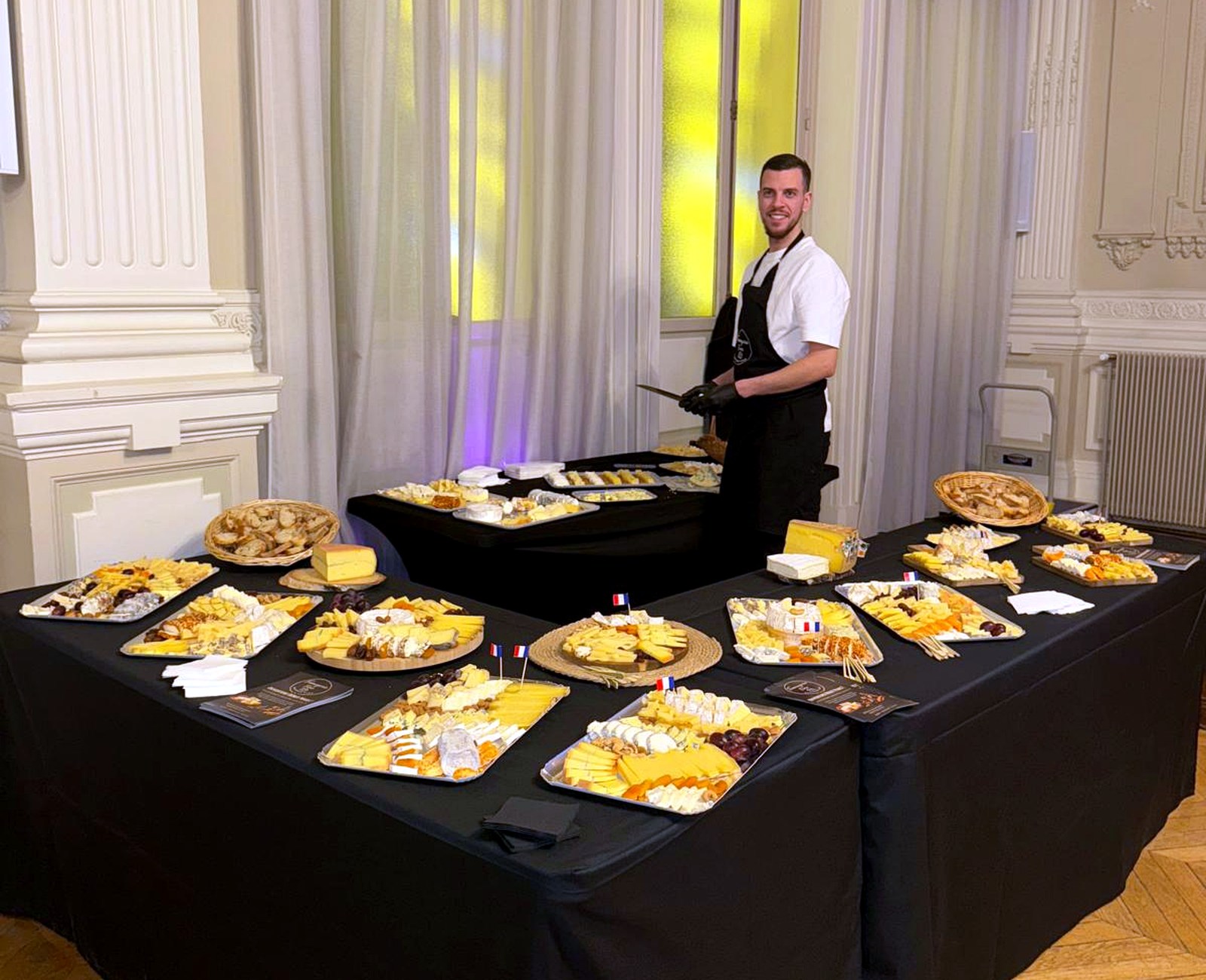 Fromagerie Fine derrière un grand buffet de fromages préparé pour une réception